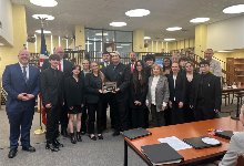 Mock trial team poses with championship plaque.