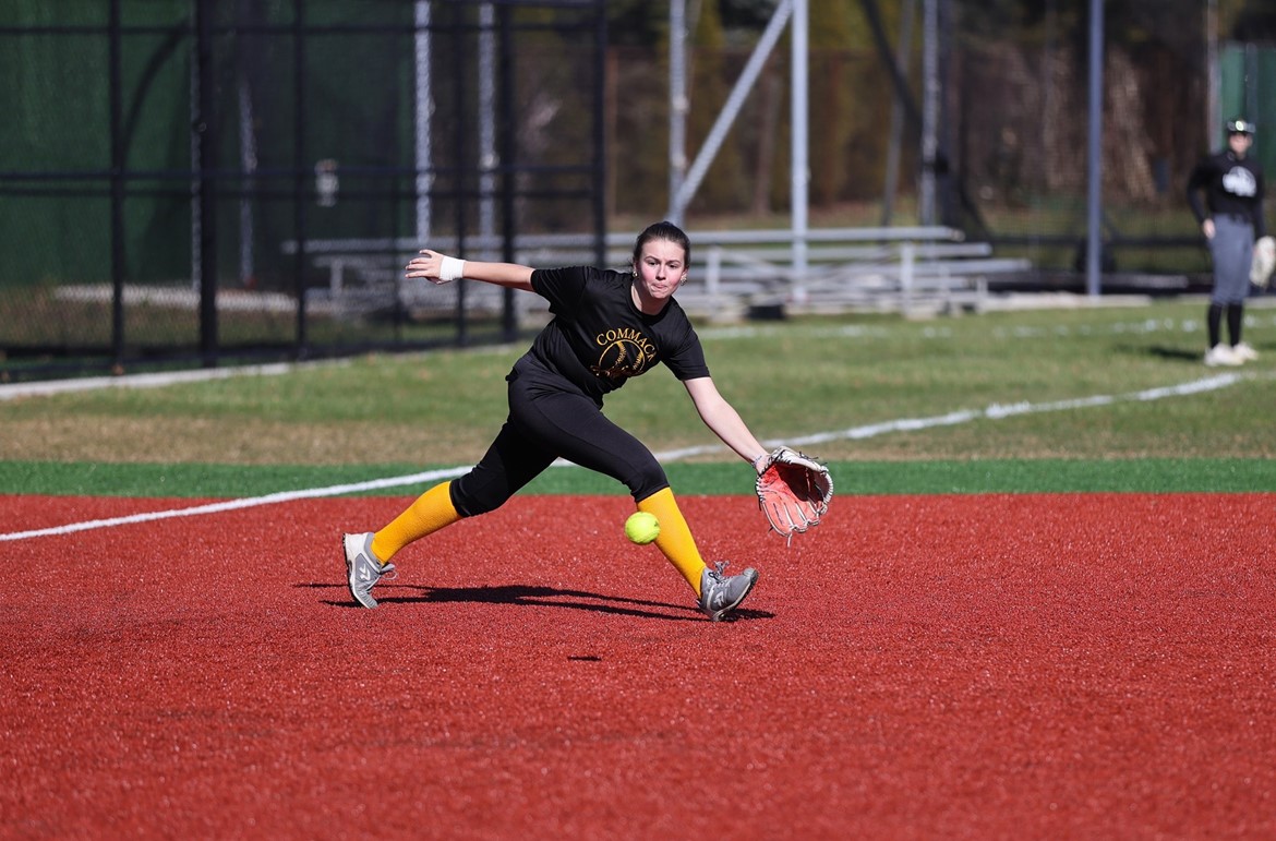 Third baseman ranges to her left to field a groundball during the first day of softball practice.