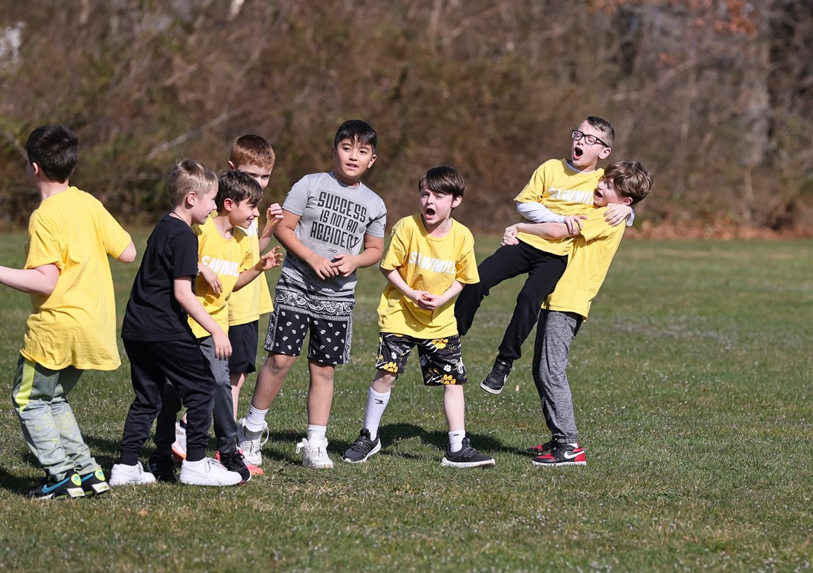 Third graders celebrate scoring goal while playing soccer. 