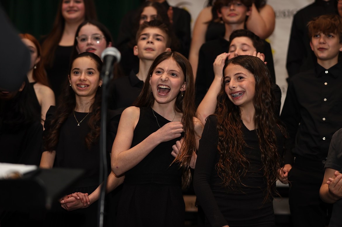 Students smile during choral performance.