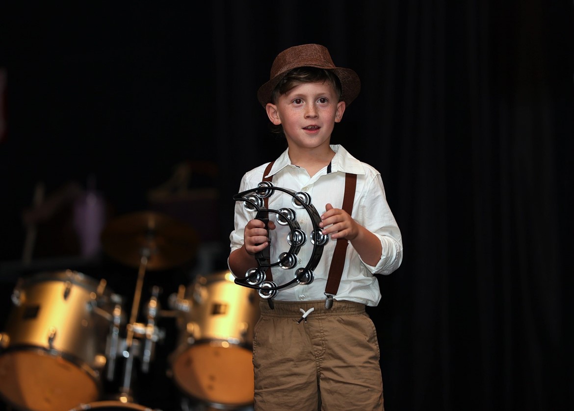 Student plays tamborine in Sawmill talent show.