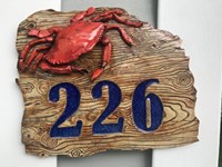 Ceramic address plaque with faux wood grain, melted blue glass, and a crab sculpture